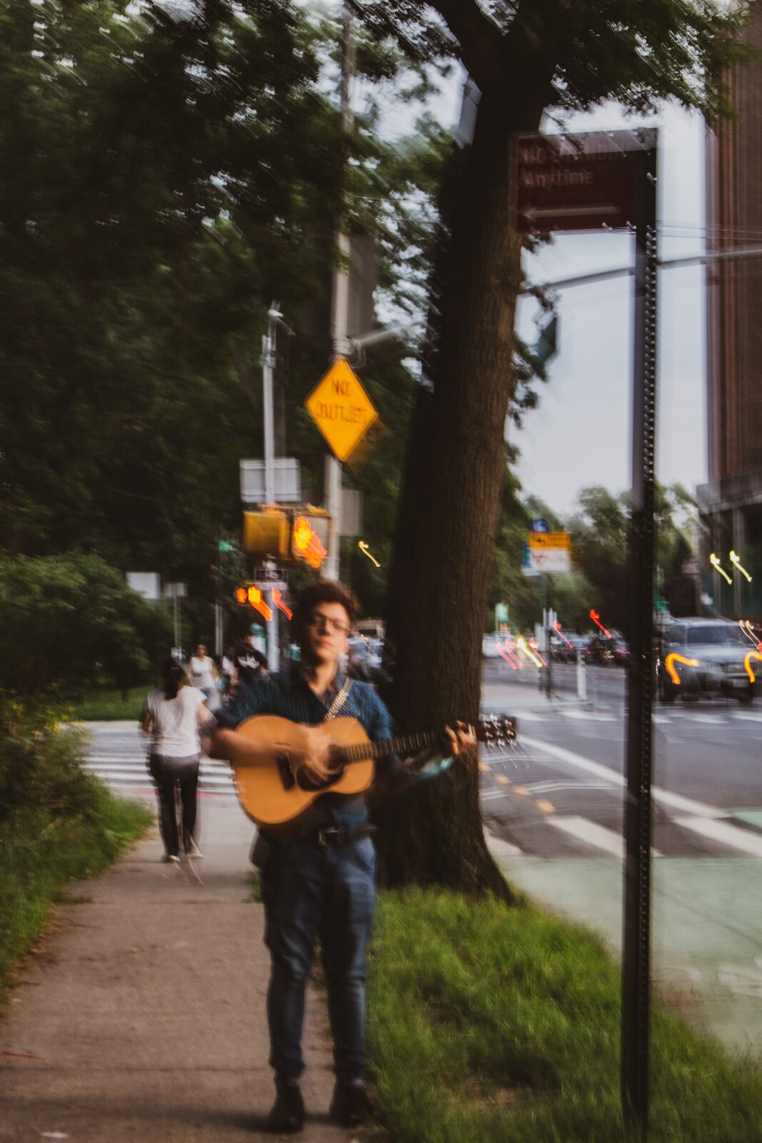 El Científico con una guitarra acústica en una acera de Nueva York